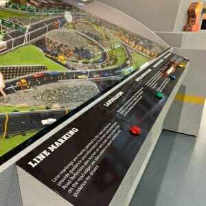 Scale model showing a road with vehicles on a clear terrain