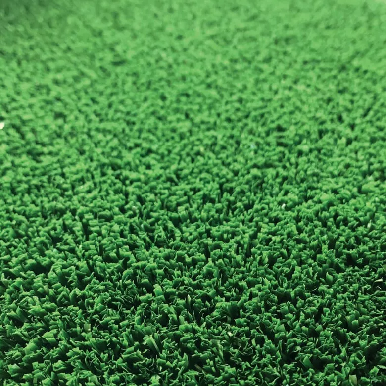 Close-up image of a green artificial turf surface. The textured, vibrant grass-like material conveys a fresh and lively tone, covering the entire frame