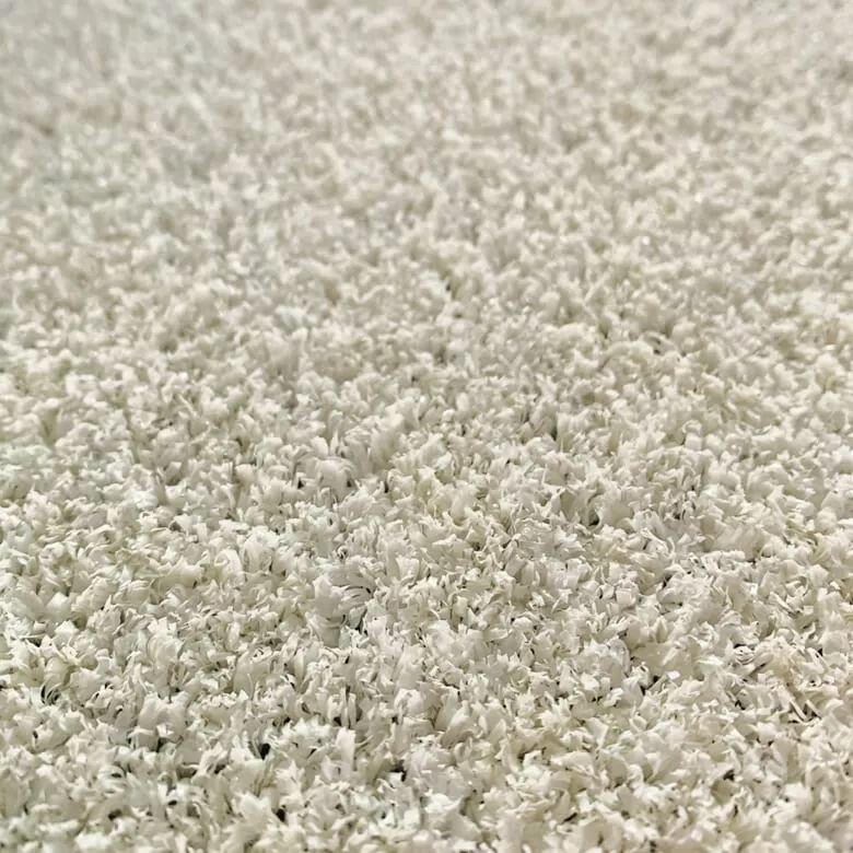 Close-up of white textured surface resembling tiny flower petals or shavings, creating a soft, delicate, and intricate pattern with a serene tone