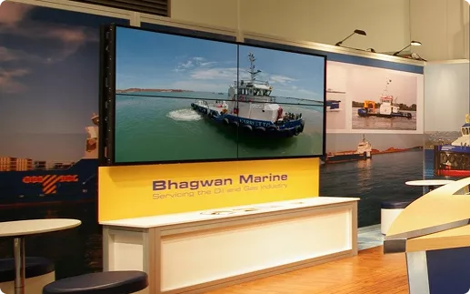 Booth display for Bhagwan Marine featuring a large image of a tugboat on water, with text "Servicing the Oil and Gas Industry." Modern and professional setup.