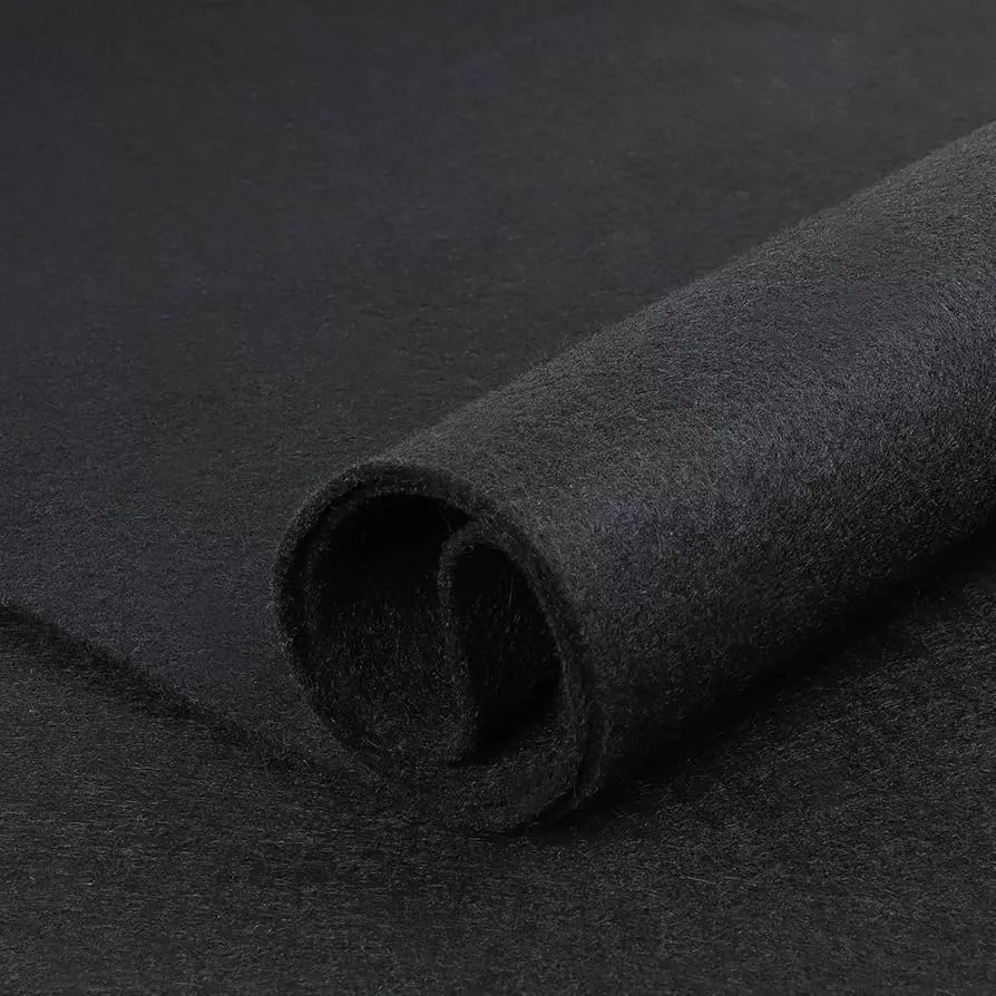 Close-up of a rolled black felt fabric on a flat surface. The texture appears soft and smooth, with a slight sheen, suggesting quality material