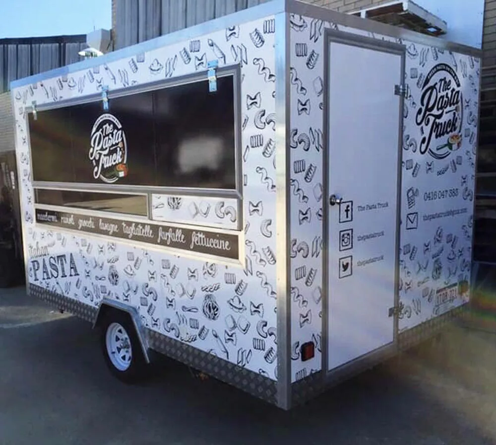 Food truck with pasta-themed graphics and "The Pasta Truck" logo. Social media icons and contact details are visible. Background is an outdoor setting
