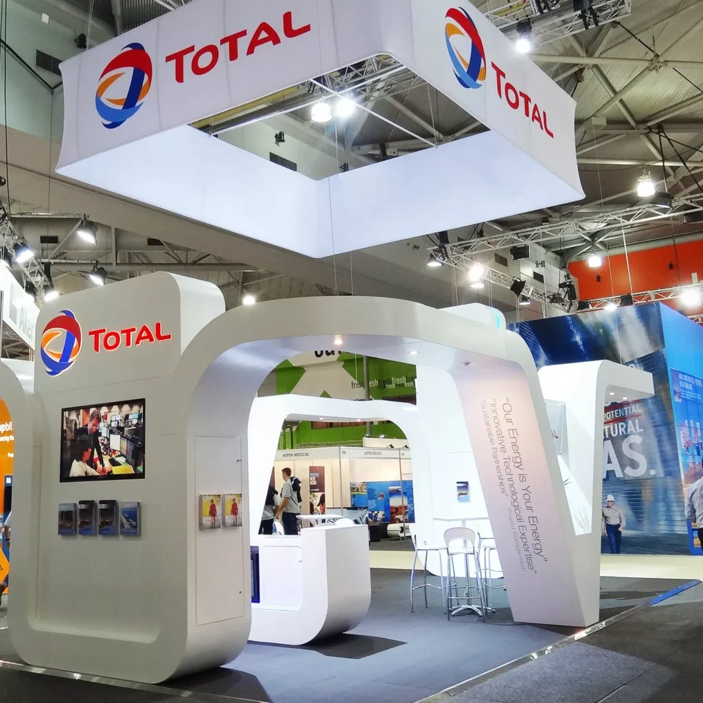 Trade show booth by Barrett Exhibition Group Perth with sleek white design, "Total" logos, screens, and brochures.