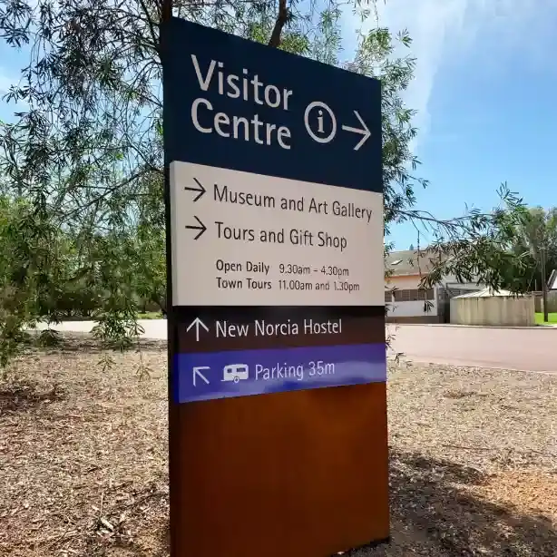 Sign in a sunlit outdoor area directs to the Visitor Centre, Museum and Art Gallery, Tours and Gift Shop, New Norcia Hostel, and Parking 35m ahead.