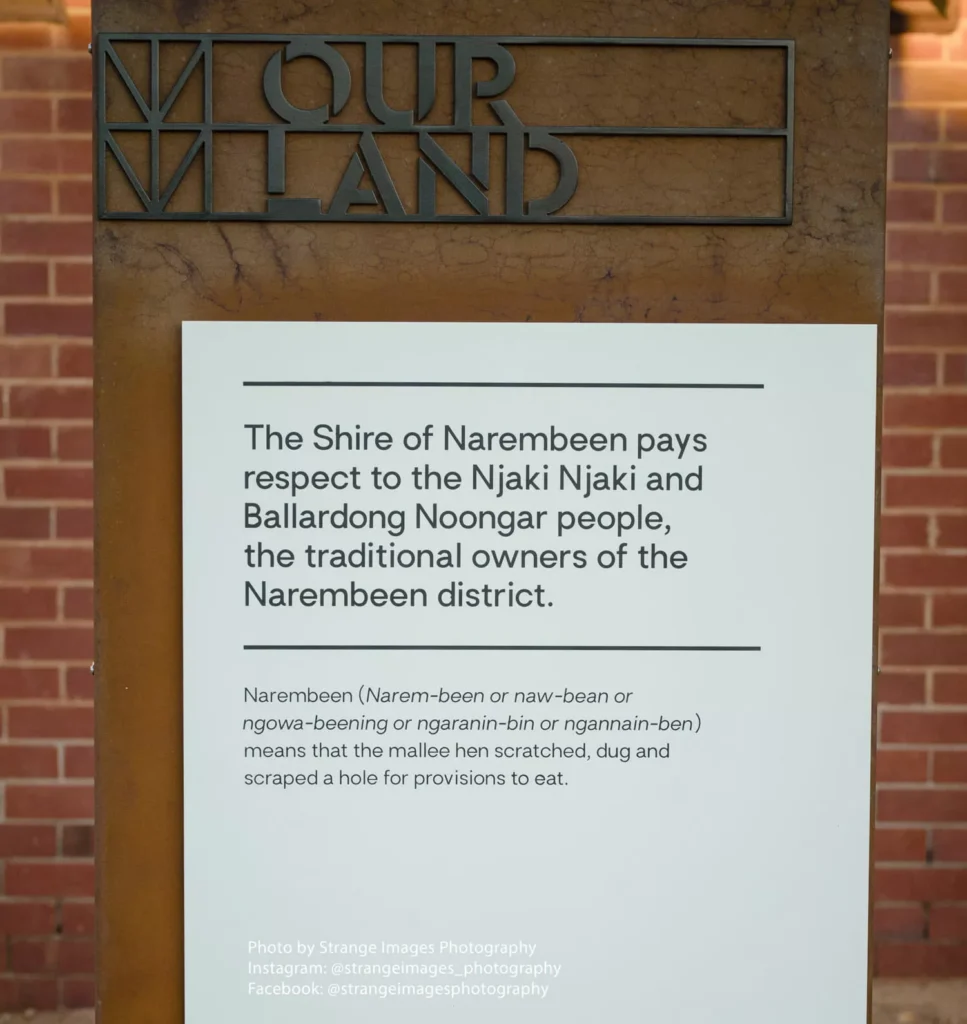 A brown sign with "OUR LAND" at the top honors the Njaki Njaki and Ballardong Noongar people as traditional owners of Narembeen, Australia