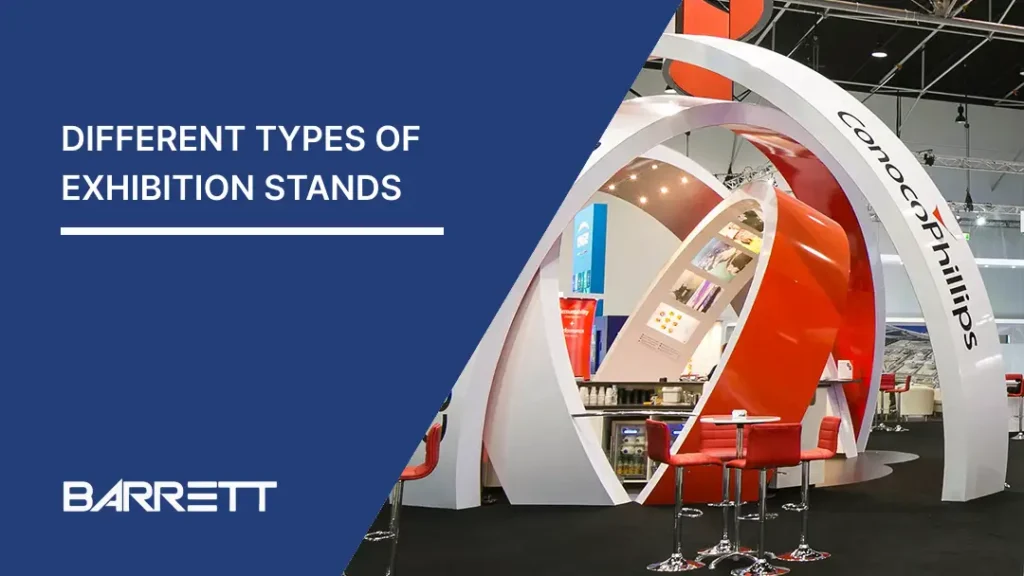 A modern exhibition stand with sleek red and white curved structures, displaying ConocoPhillips branding. Nearby are red bar stools and promotional materials.