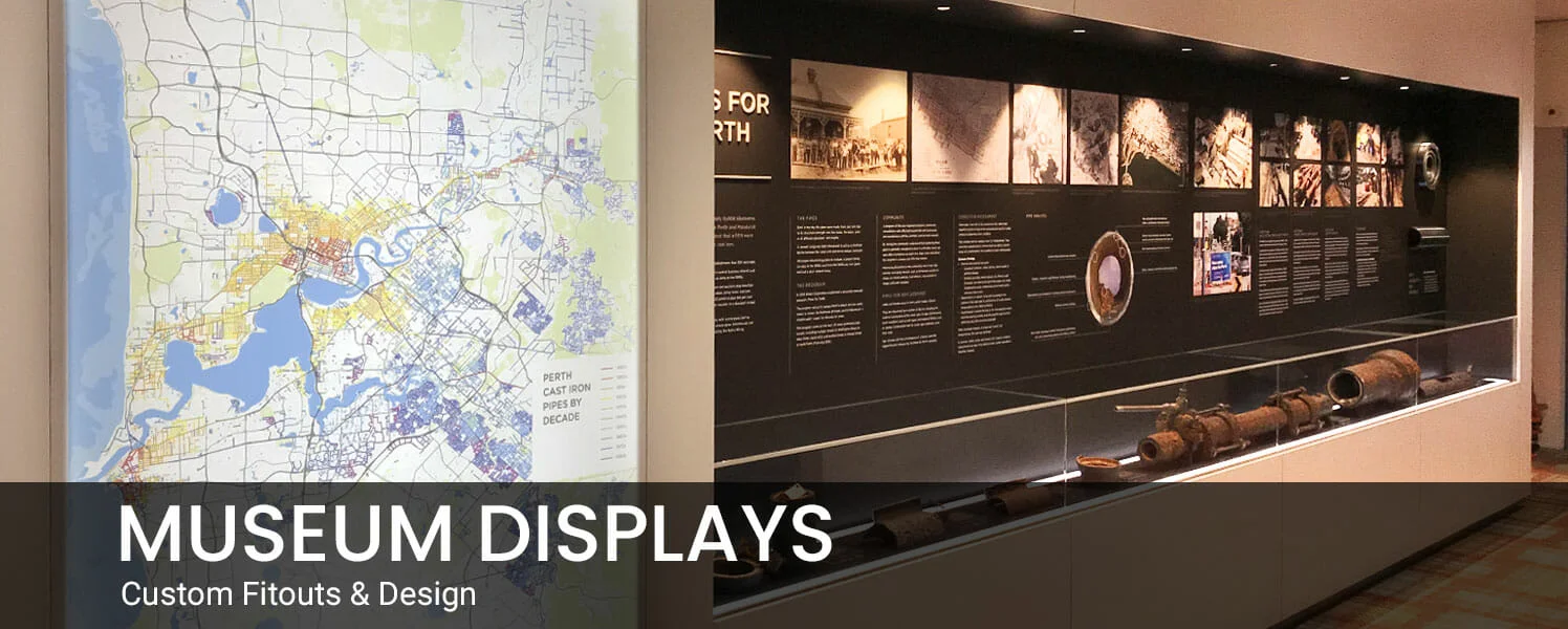 Museum display with a detailed map on the left and informative wall with text and historical images on the right, creating an educational atmosphere.